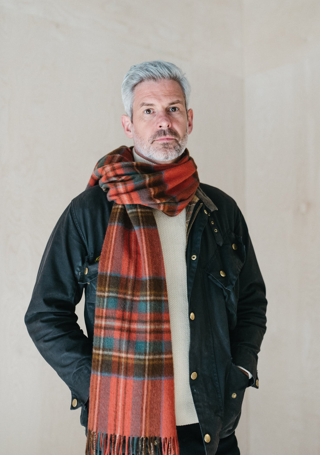 TBCo Mens Lambswool Scarf in Stewart Royal Antique Tartan styled with navy jacket and cream jumper, displaying plaid pattern