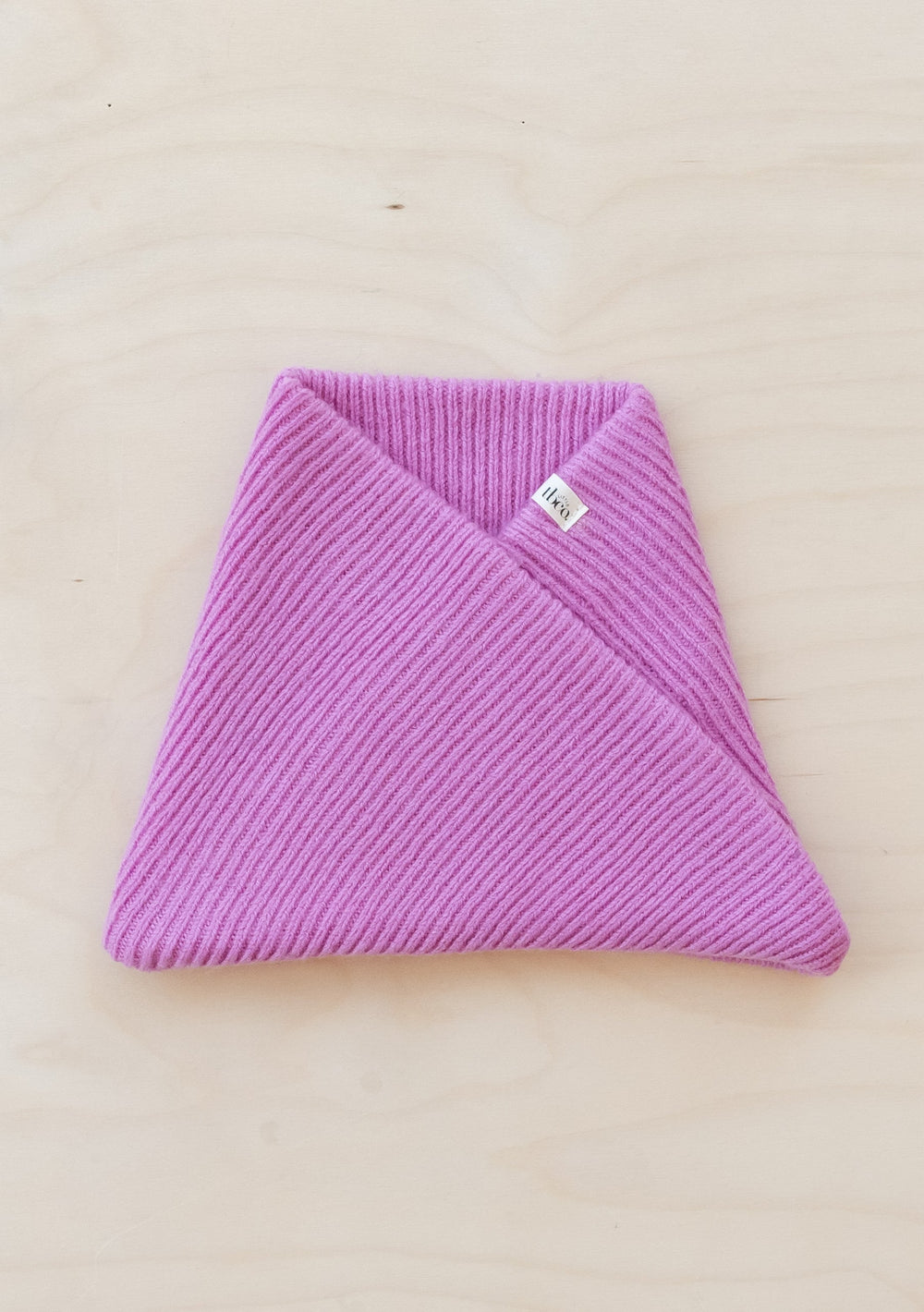 Pink ribbed TBCo Merino Wool Kids Neck Warmer folded to show cosy knit texture and small brand label