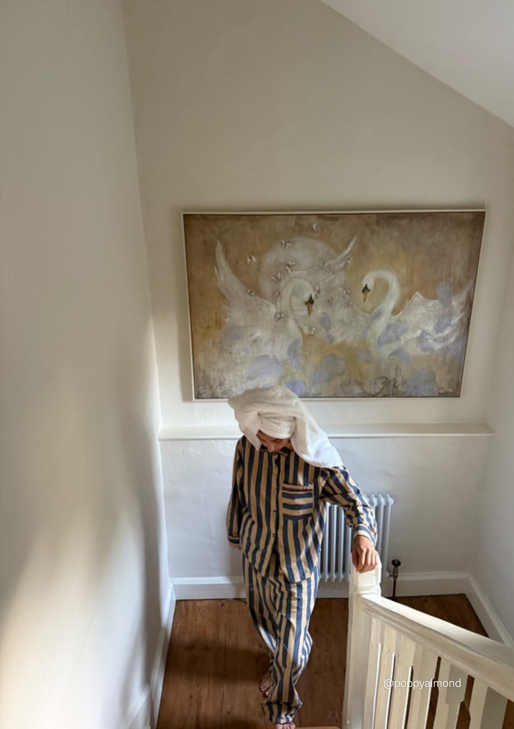 Woman wearing TBCo Cotton Pyjamas in Navy Stripe with red piping and scalloped collar walking downstairs with towel on head