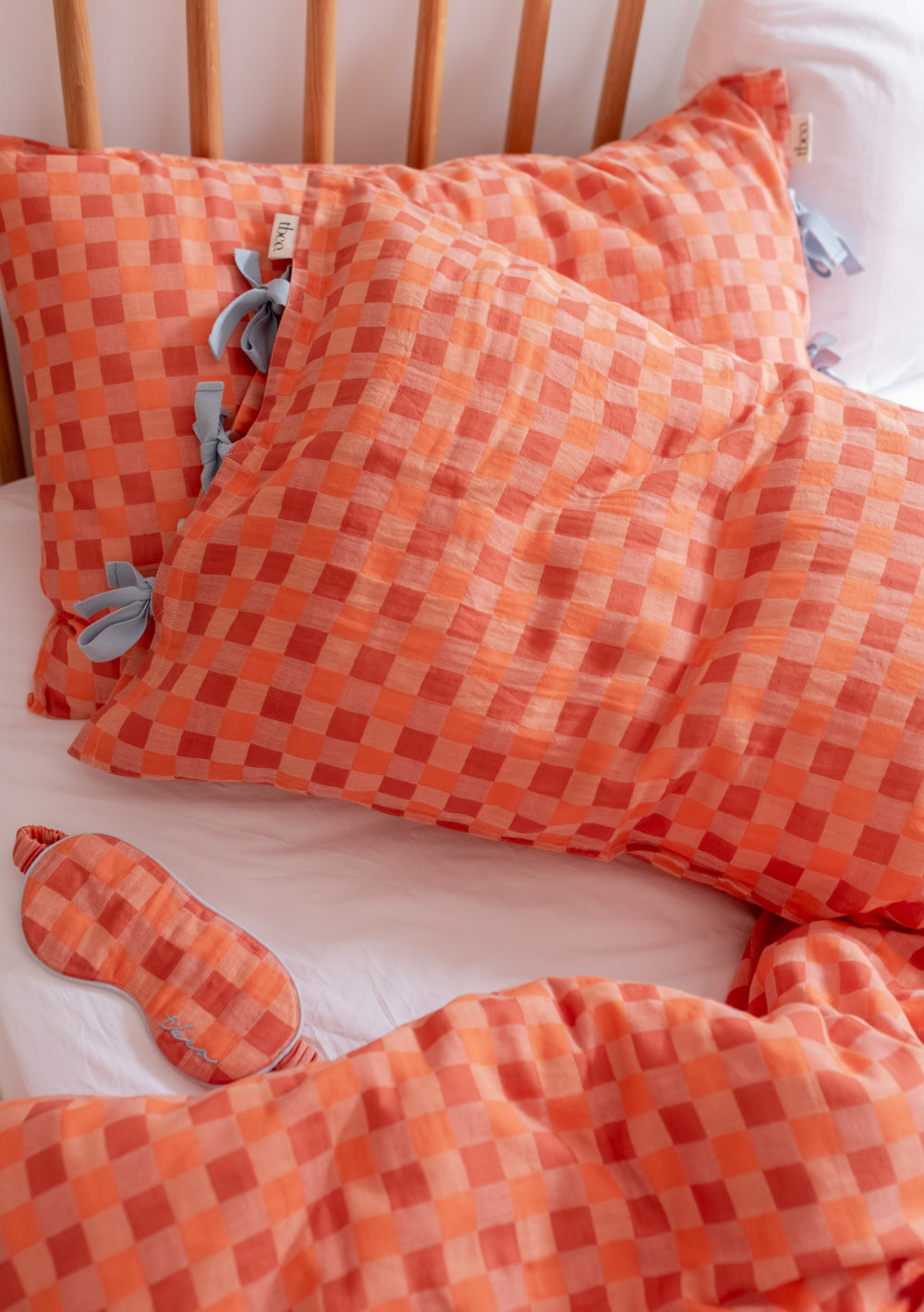 TBCo Cotton Pillowcases in Apricot Checkerboard pattern with blue ties, showcasing textured squares and matching eye mask