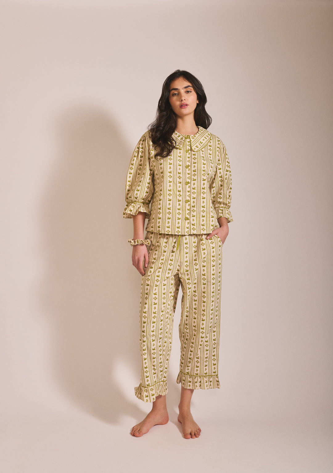 Model wearing TBCo Cropped Cotton Pyjamas in Olive Swan with puff sleeves and ruffle detail on cropped trousers