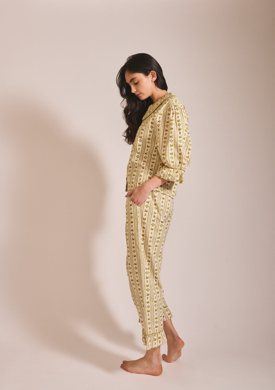 Side profile of model in TBCo Cropped Cotton Pyjamas in Olive Swan featuring striped floral print and relaxed fit design