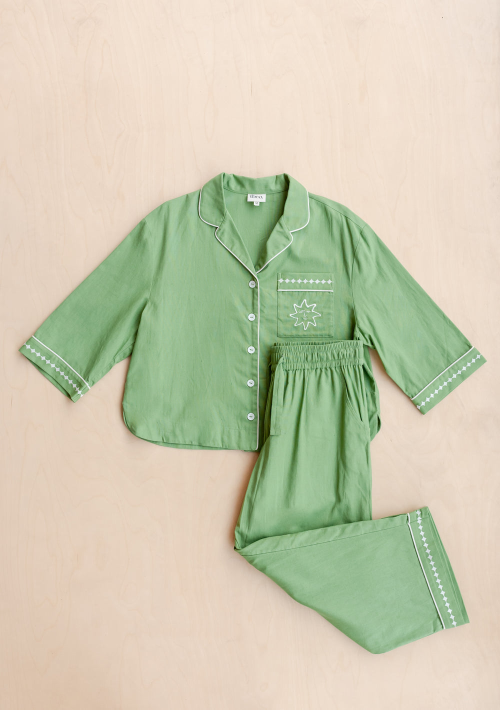 TBCo Cotton & Linen Pyjamas in green with embroidered sun motif and sleeve details, displayed flat on beige background