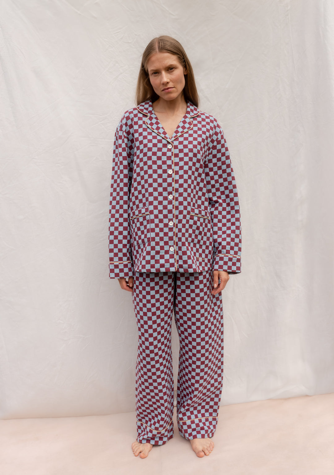 Model wearing TBCo Cotton Pyjamas in Blue Checkerboard with contrasting piping and elastic waistband.