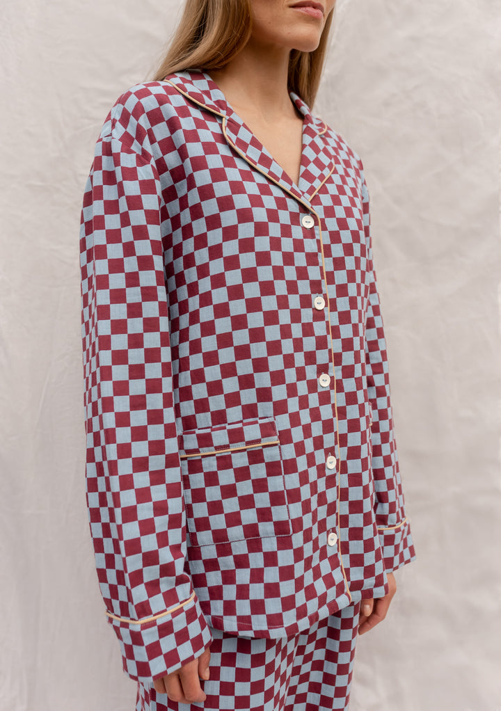 Model wearing TBCo Cotton Pyjamas in Blue Checkerboard with piping, pockets, and button-up front in breathable cotton.