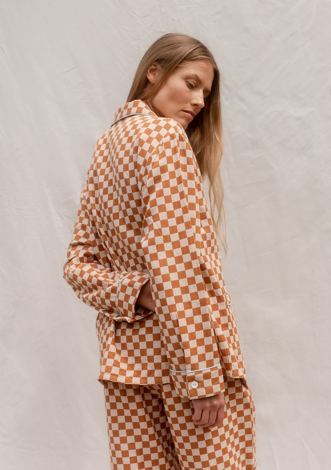 Model wearing TBCo Cotton Pyjamas in Honey Checkerboard, breathable cotton with contrasting piping and elastic waistband.