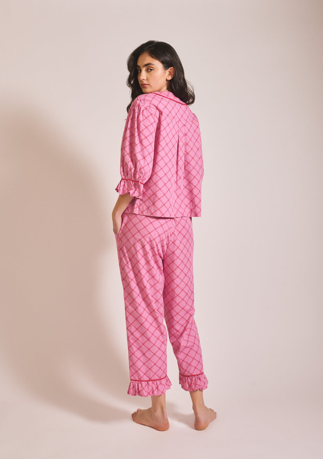 Woman in portrait pose wearing TBCo Cropped Cotton Pyjamas in Pink Lattice with ruffled cuffs, gallery image 3, 1442x2048 pixels