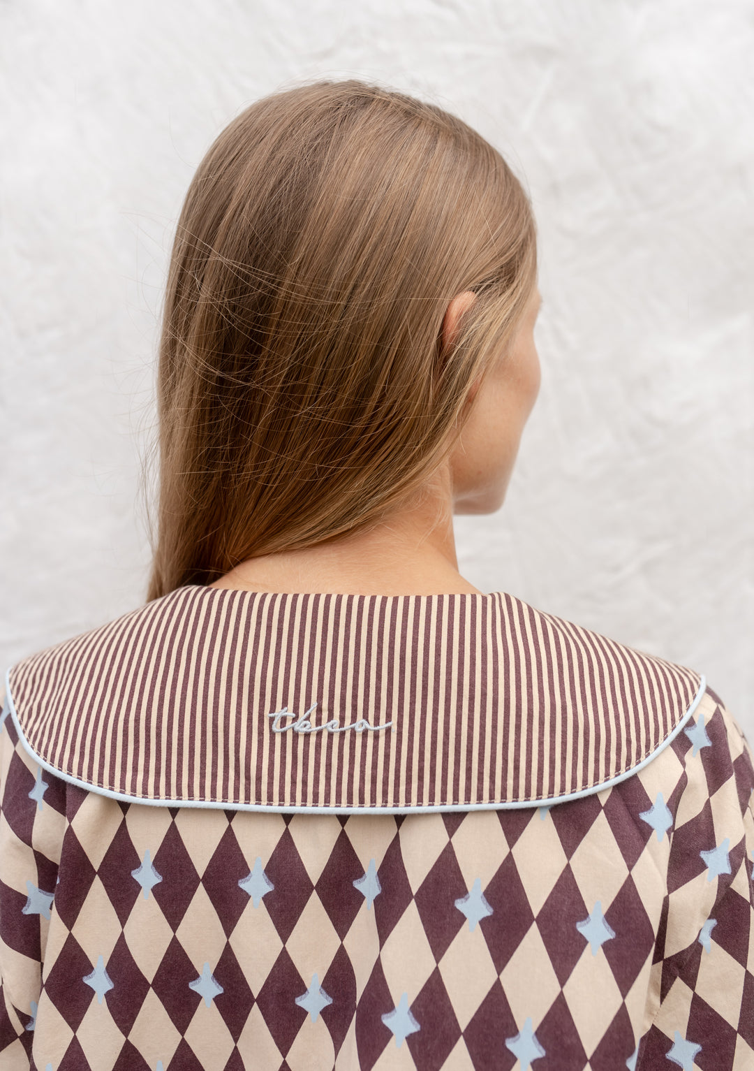 Back view of TBCo Cotton Pyjamas in Camel Harlequin with striped collar and embroidered logo on camel diamond pattern.
