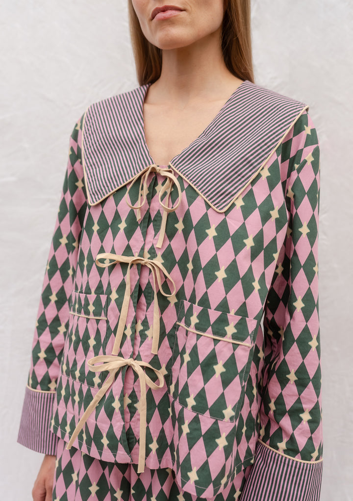 Cotton Pyjamas in Pink Harlequin by TBCo, featuring breathable cotton, bold diamond pattern, camel bows, and striped collar.