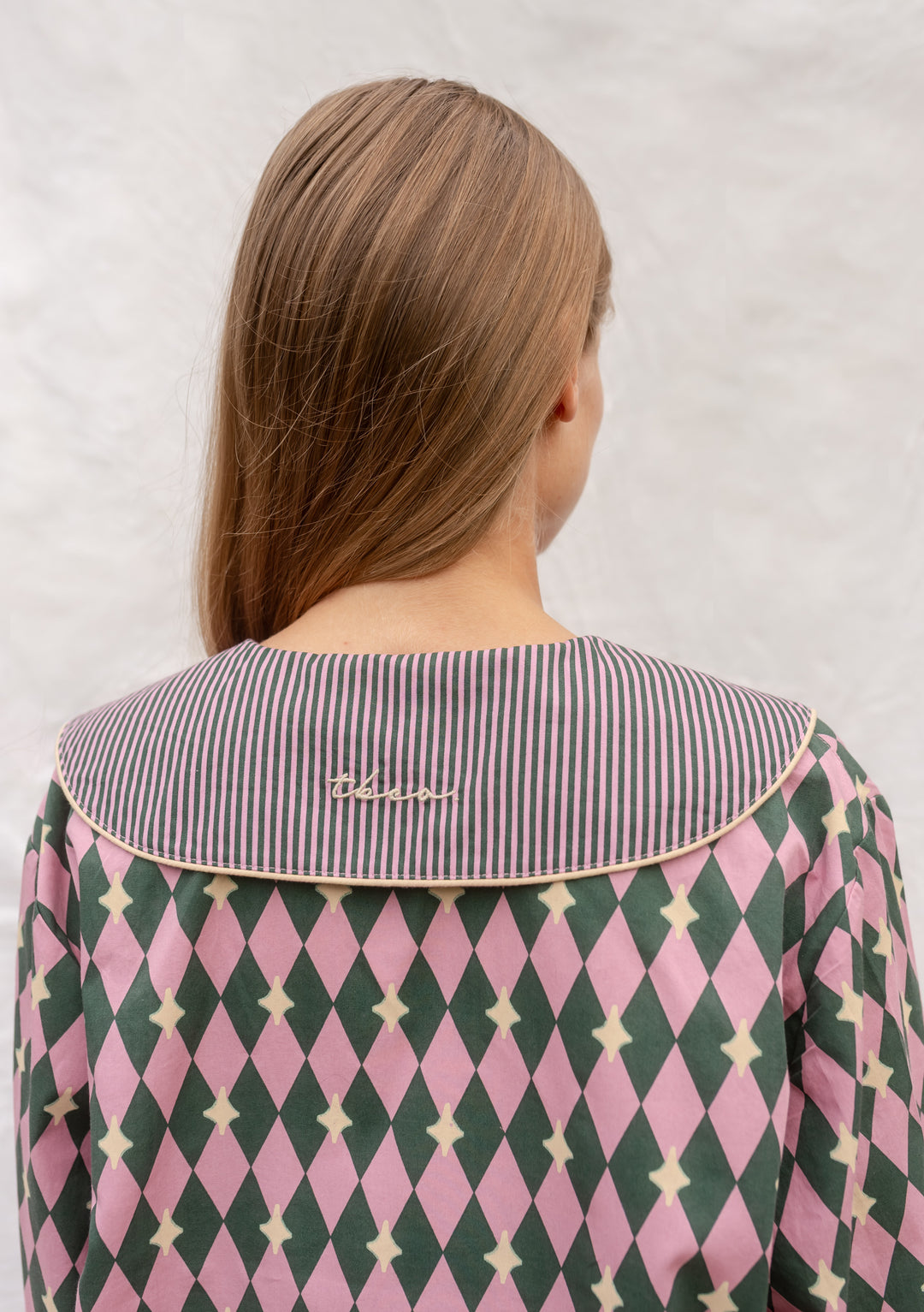 Back view of TBCo Cotton Pyjamas in Pink Harlequin featuring embroidered collar and diamond pattern.