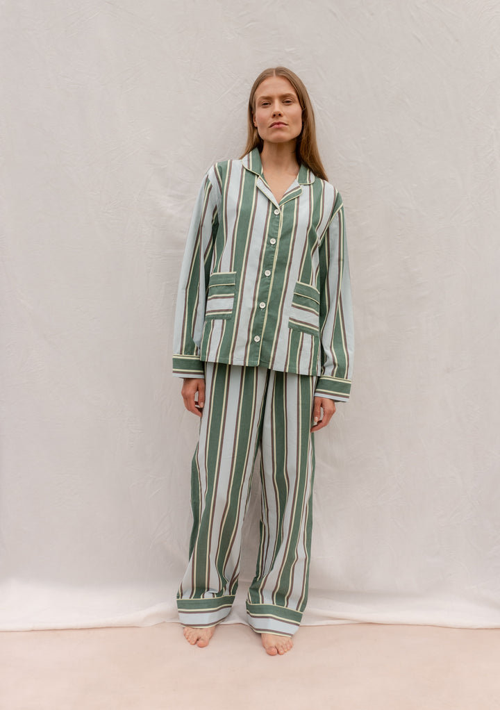 Model wearing TBCo Cotton Pyjamas in Blue Stripe, featuring breathable cotton, tailored stripes, buttons, and pockets.