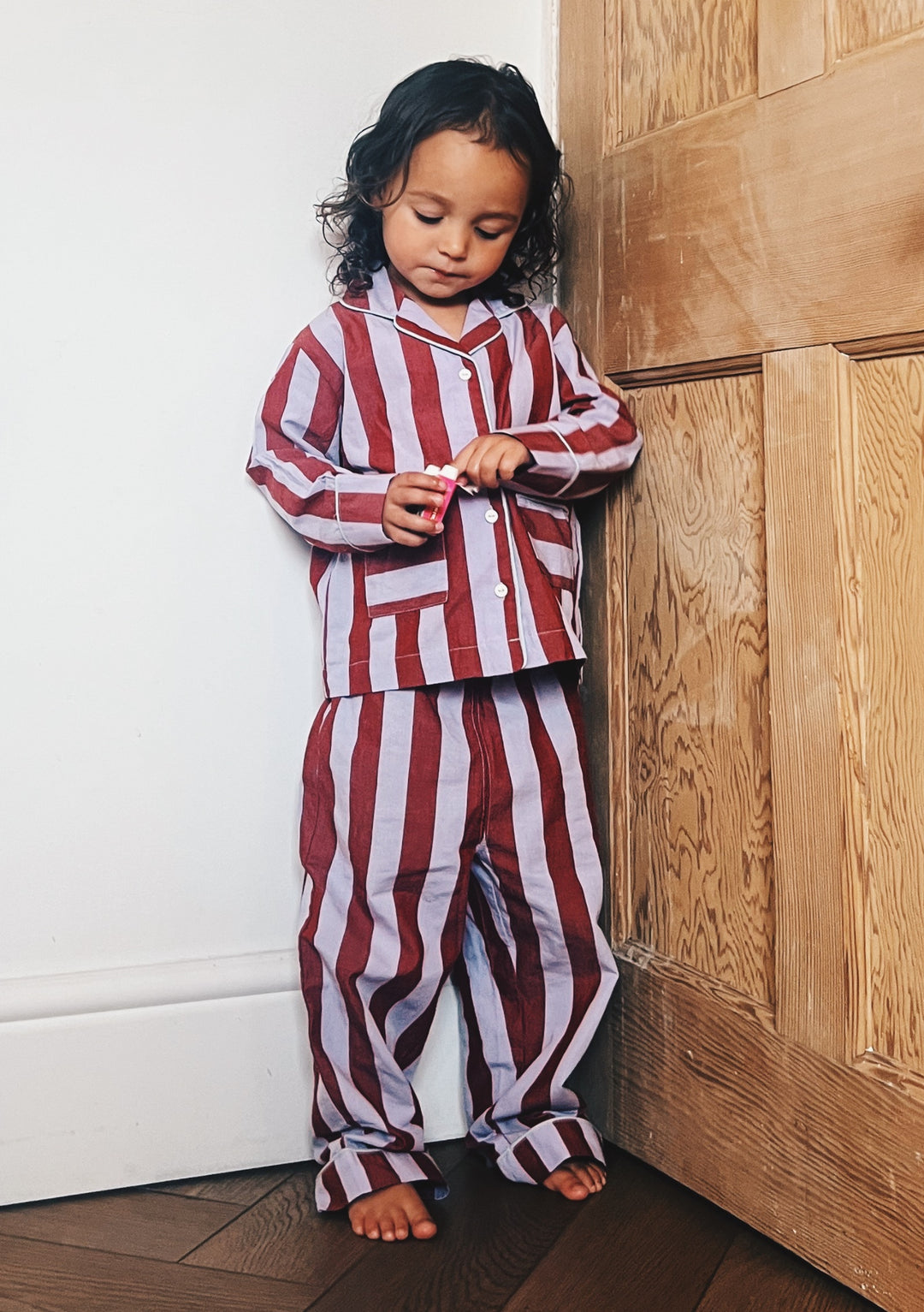 Child wearing TBCo Cotton Kids Pyjamas in Lilac Stripe with pockets, made from 100% cotton for cosy comfort.