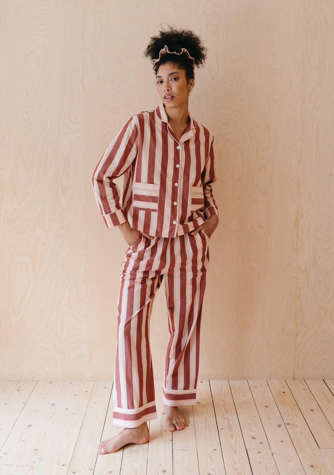 Striped cotton pyjama set from TBCo featuring red and cream stripes, collared top and wide-leg trousers with pockets and piping detail