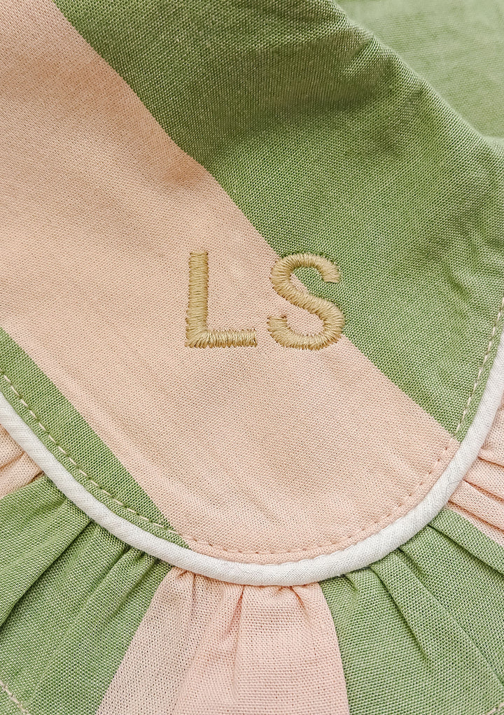 Close-up of TBCo Cotton Pyjamas in Orange Stripe showing personalised LS monogram embroidery on pink and green fabric detail