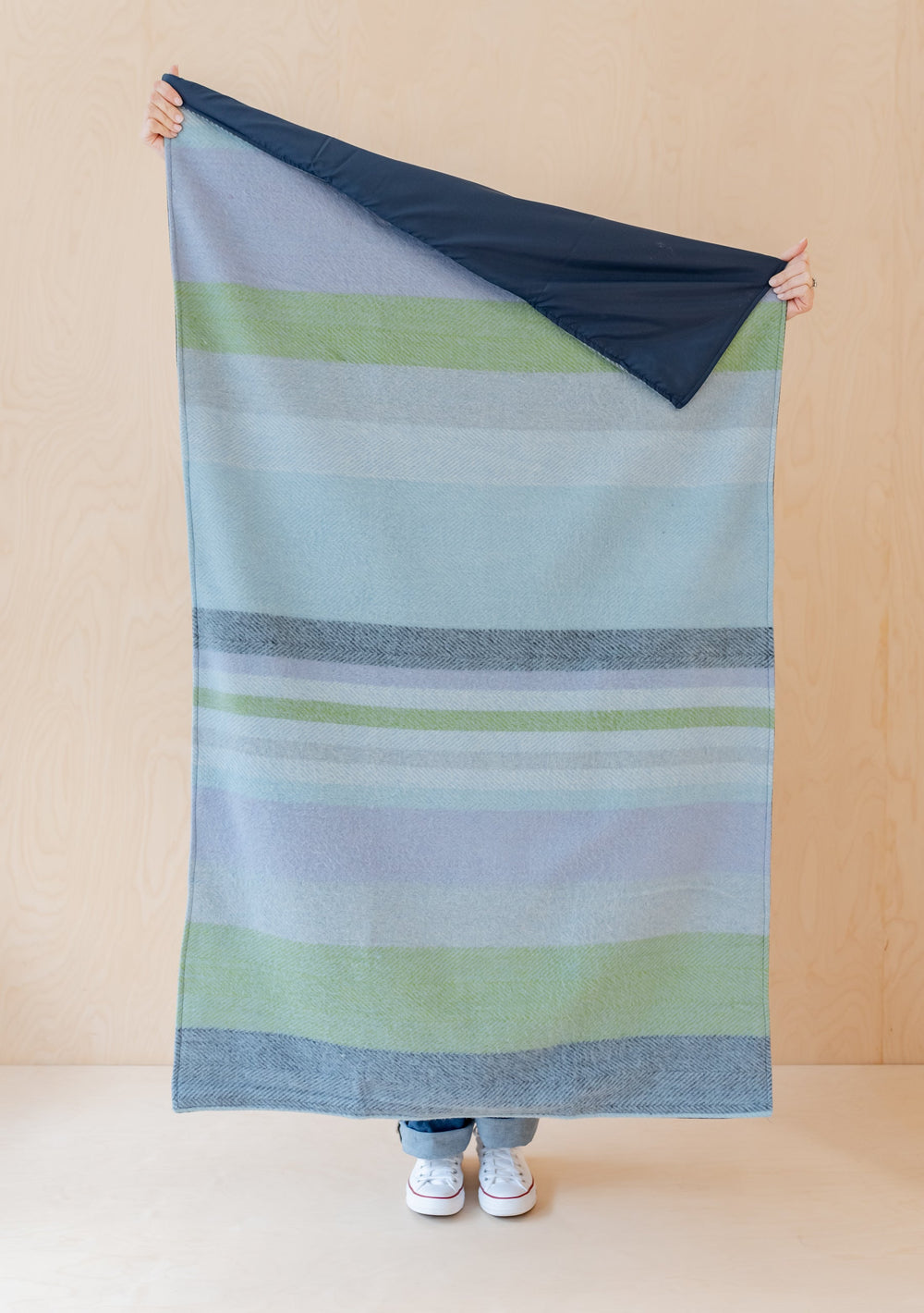 TBCo Recycled Wool Small Picnic Blanket featuring blue and green stripes with water-resistant backing, displayed against neutral wall