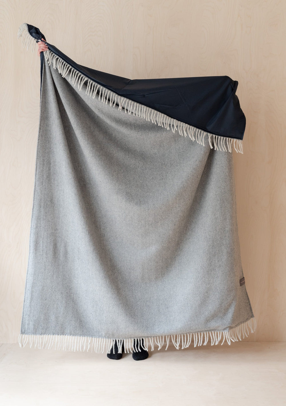 TBCo Recycled Wool Picnic Blanket displayed in charcoal grey herringbone pattern with white fringe and black waterproof backing