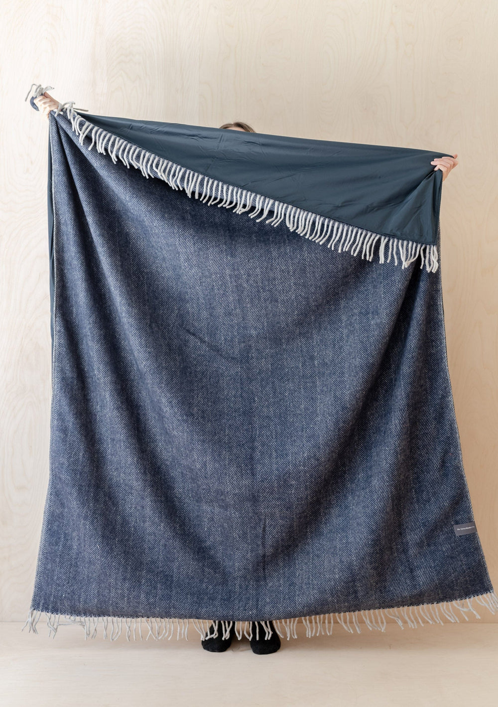 TBCo Recycled Wool Picnic Blanket in navy herringbone pattern with fringe detail and waterproof backing displayed stretched out