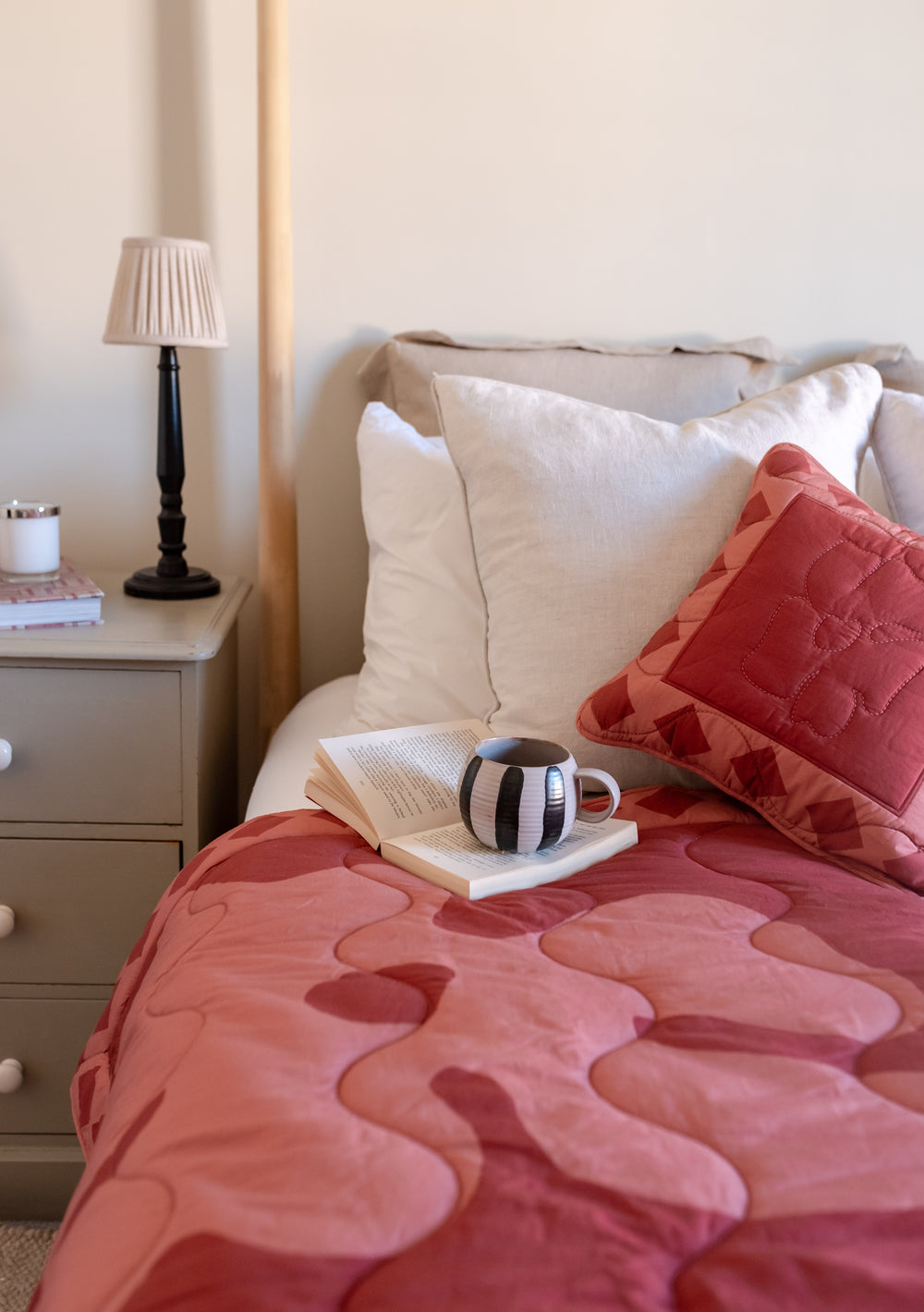 TBCo Quilted Cotton Throw in Flora displayed on bed with matching cushion, book and bedside lamp in cosy bedroom setting