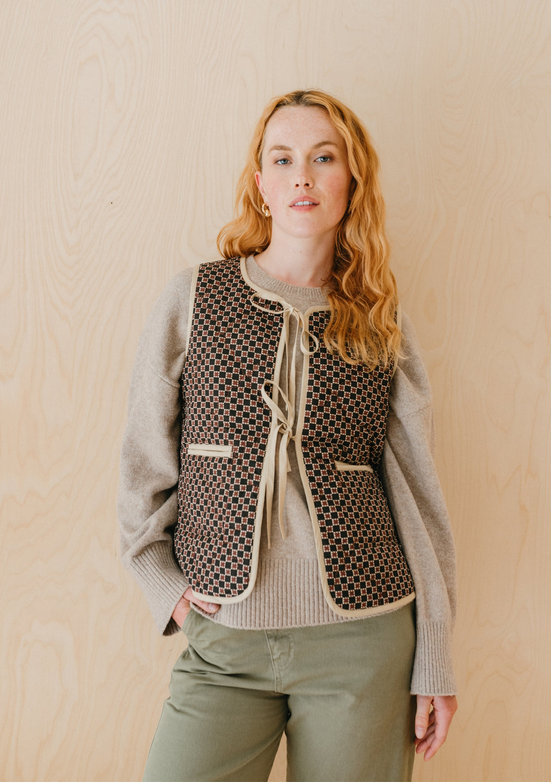 TBCo Quilted Cotton Vest in reversible brown celestial stripe, styled with grey jumper and olive trousers against neutral background