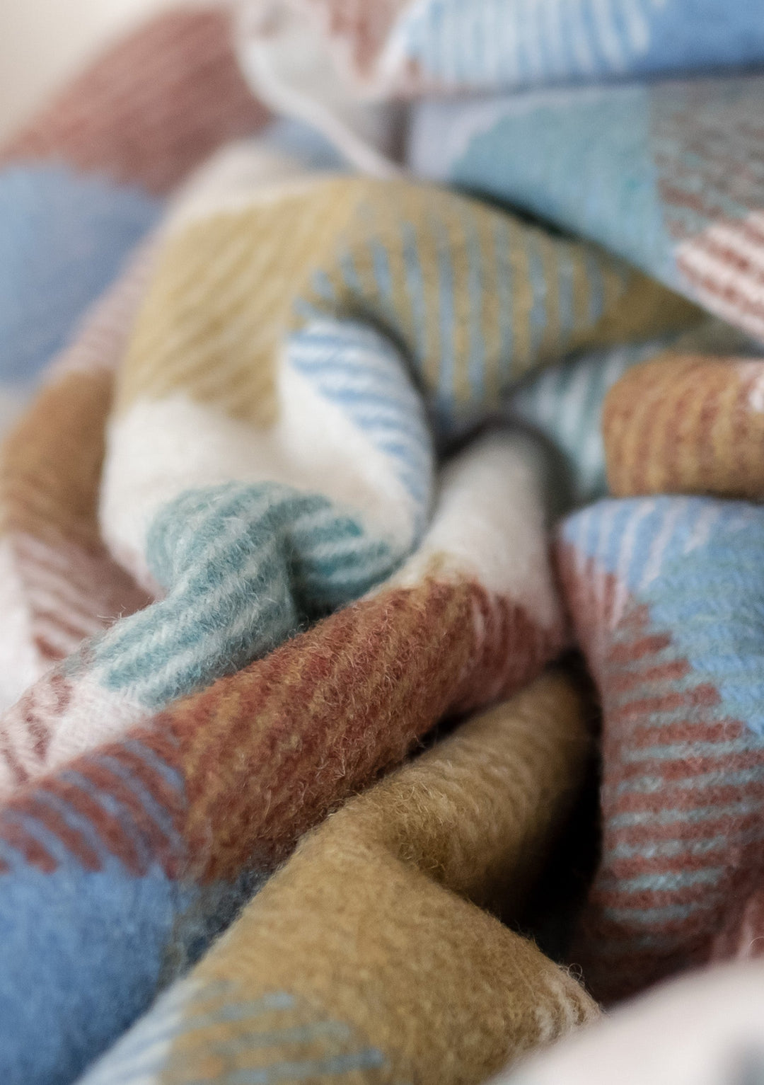 TBCo Recycled Wool Small Picnic Blanket in rainbow herringbone check, showing soft textured weave in pastel blue, brown and yellow tones