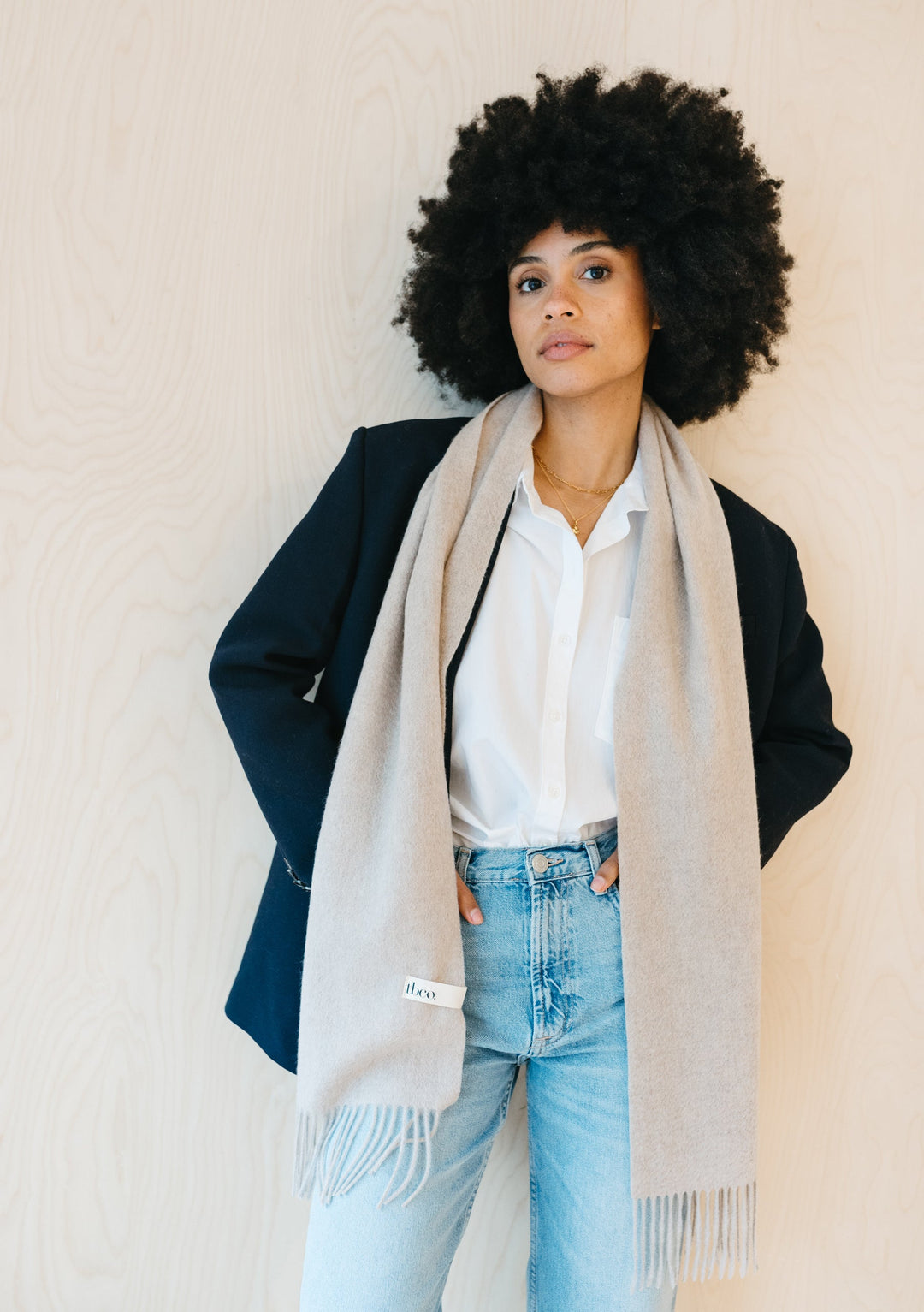 TBCo Cashmere Scarf in Oatmeal Melange elegantly draped over black blazer with fringed detail against light backdrop