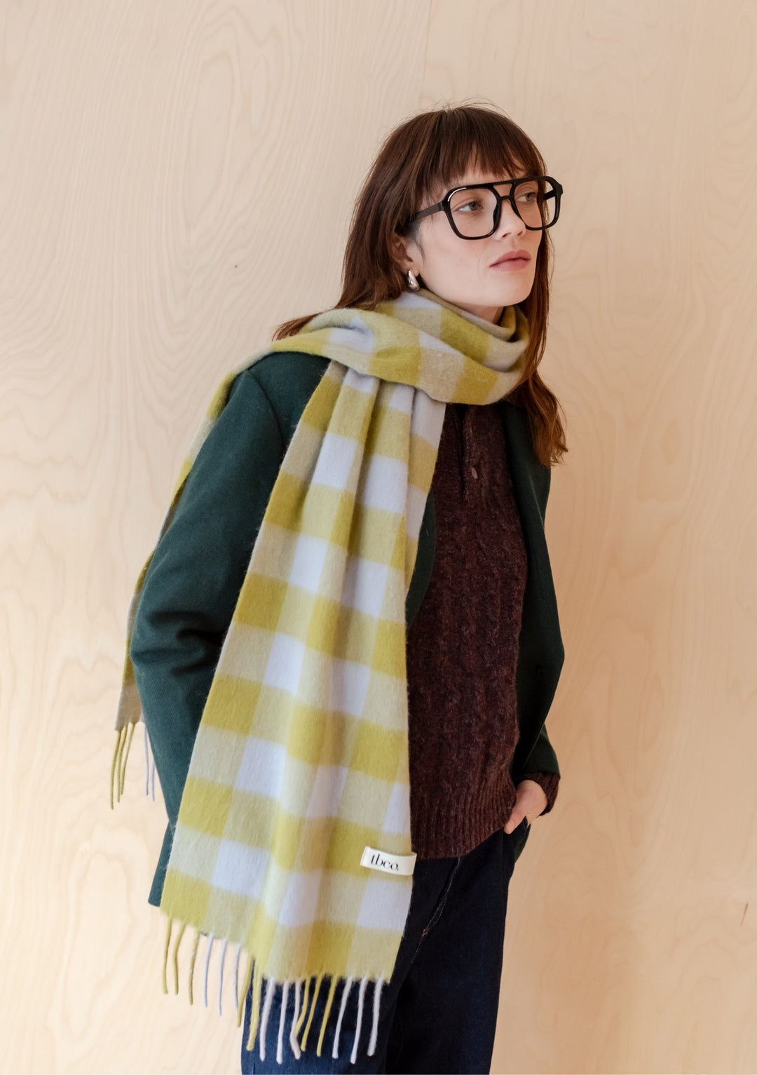 Soft lambswool TBCo scarf in avocado green and white gingham pattern with fringed edges styled with dark green coat