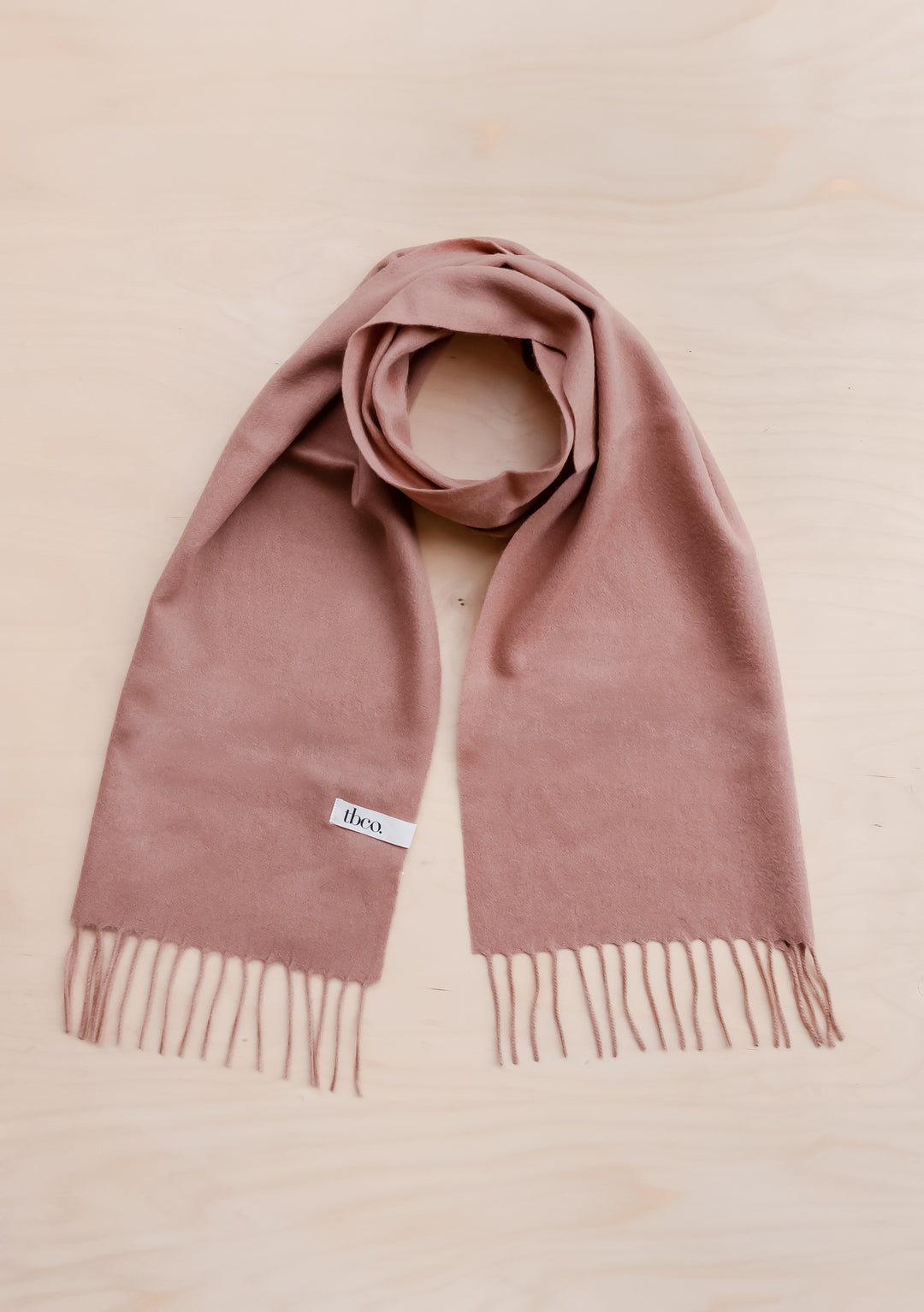 TBCo Lambswool Scarf in Blush displayed flat with fringed ends, showcasing soft pink colour and premium wool texture