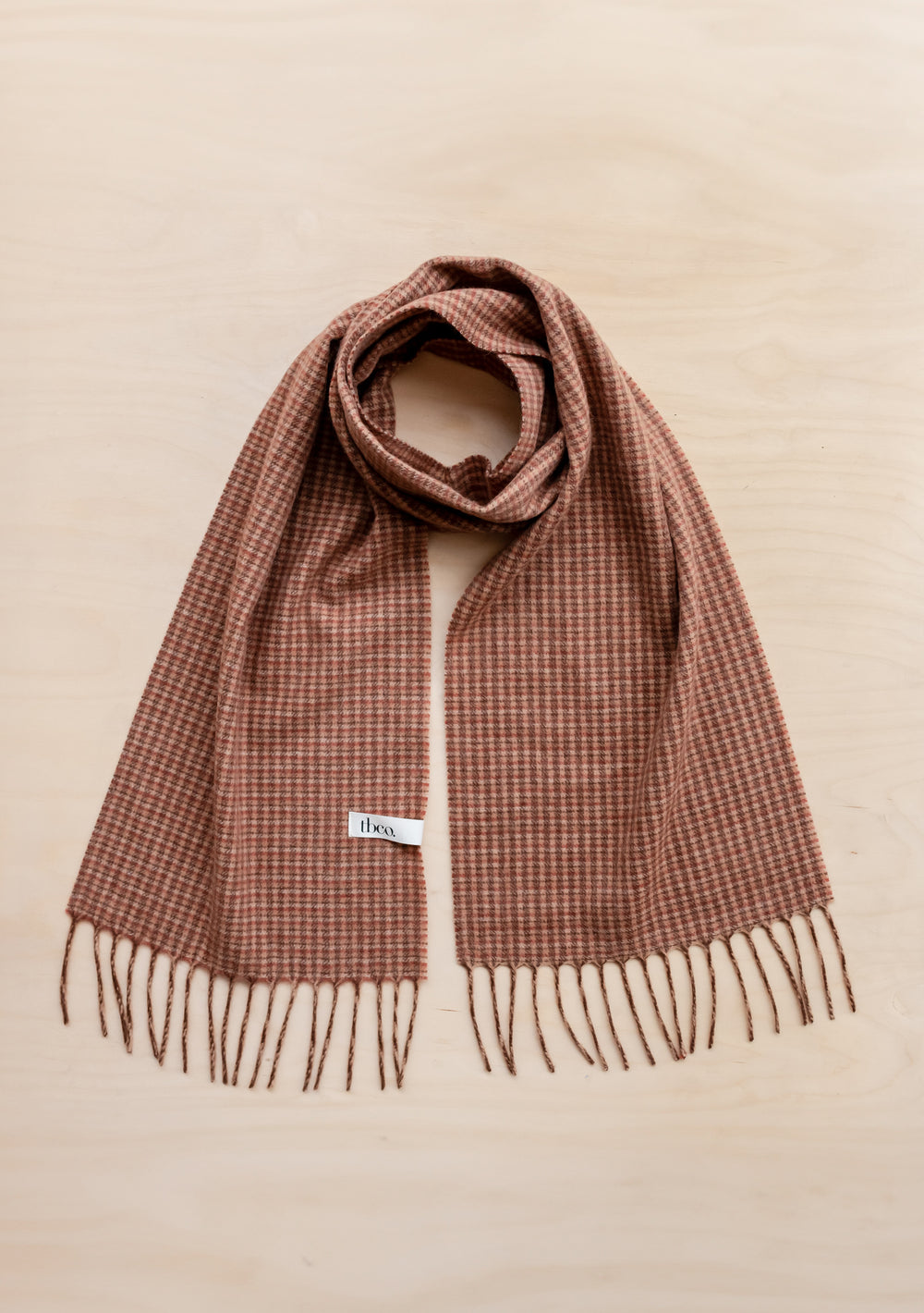 TBCo Lambswool Scarf in Camel Tweed Check featuring brown and cream check pattern with fringed ends, laid flat on beige surface