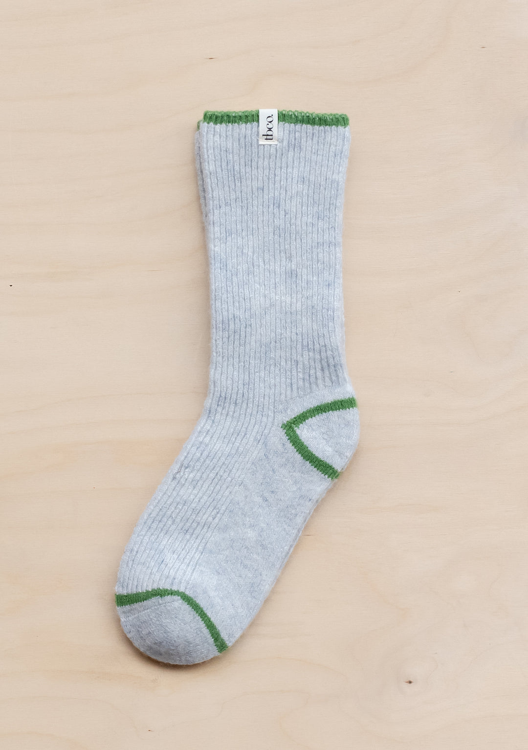 TBCo Cashmere & Merino Tipped Socks in grey with green accents at toe, heel and cuff, displayed on beige surface