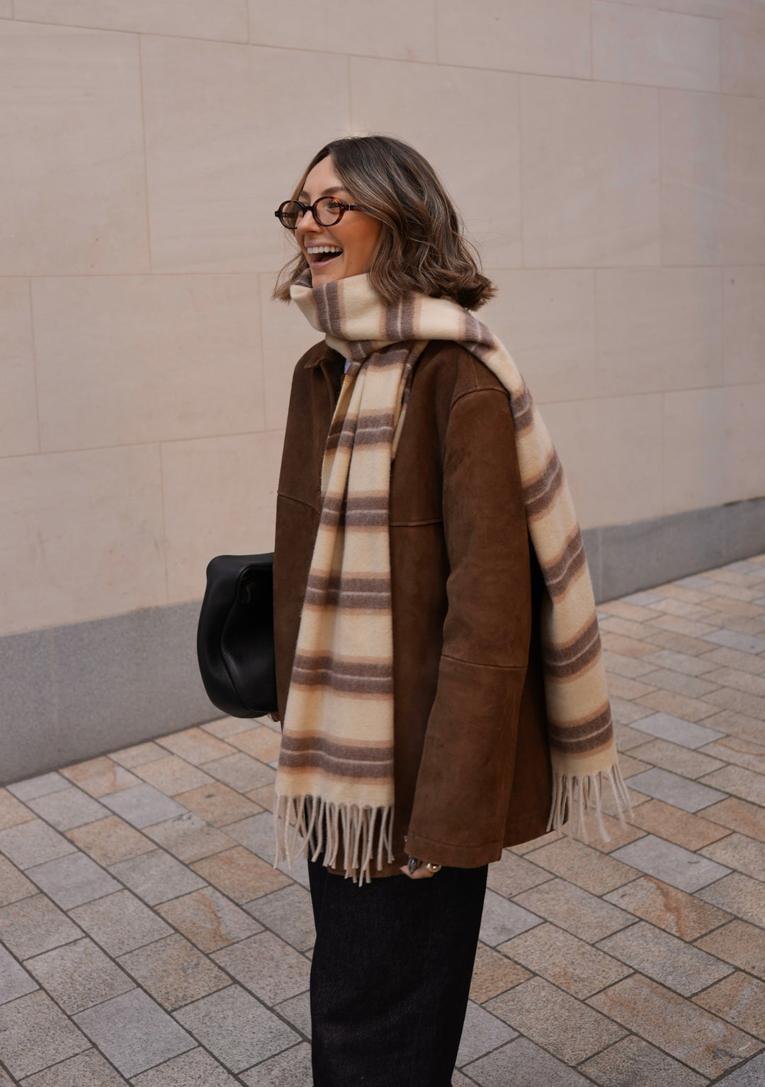 TBCo x Chloe Hayward Banoffee scarf in brown and cream stripes styled with brown coat, showcasing luxurious lambswool texture