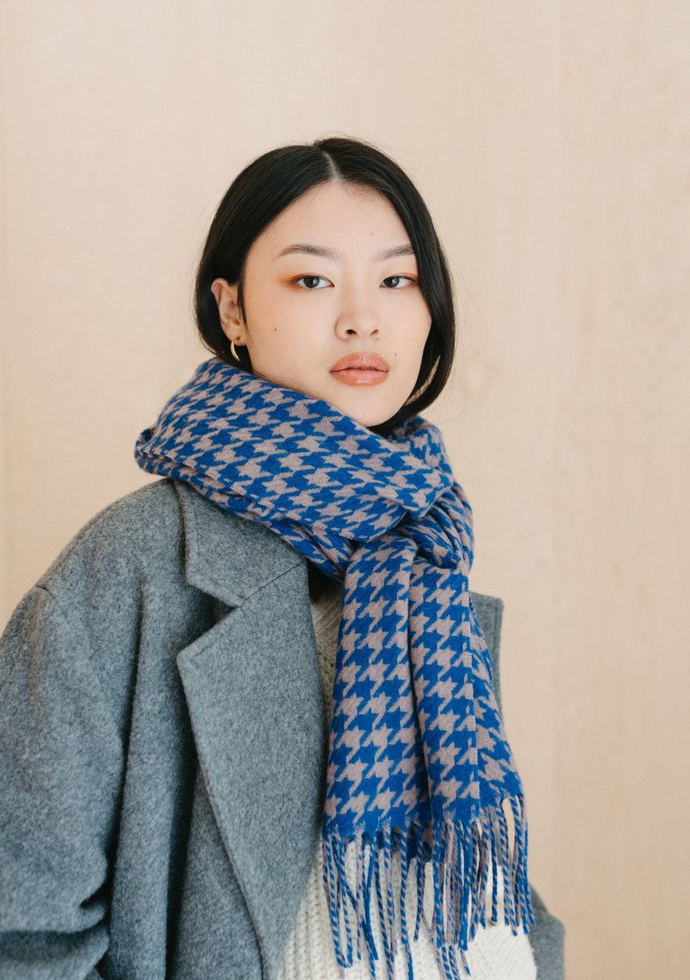 TBCo Lambswool Oversized Scarf in Slate Houndstooth styled with grey coat showing blue and grey pattern with fringe detail