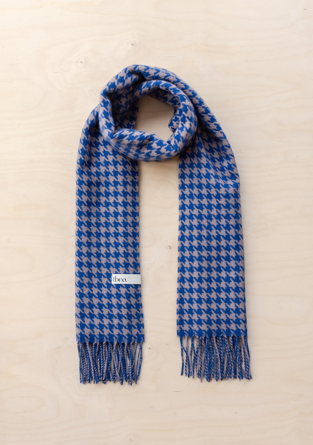 TBCo Lambswool Oversized Scarf in Slate Houndstooth pattern, featuring blue and grey tones with fringed ends, elegantly draped