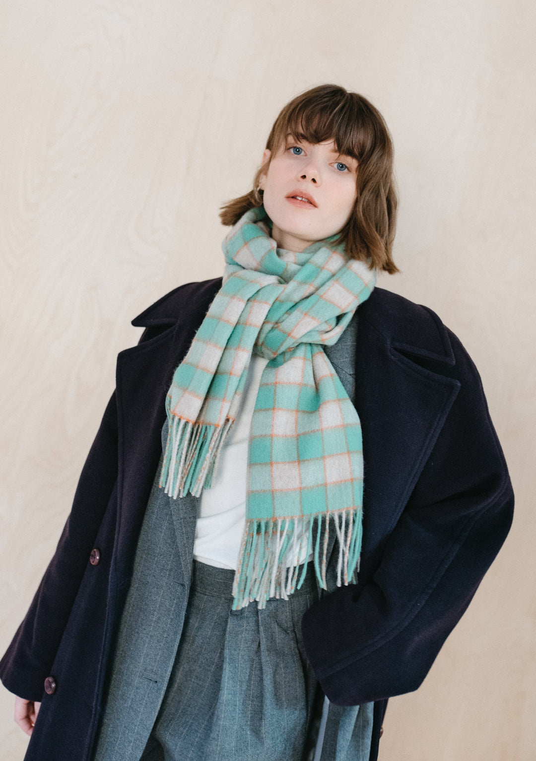 TBCo Lambswool Oversized Scarf in Mint Gingham styled with navy coat and grey trousers, showing mint and grey check pattern