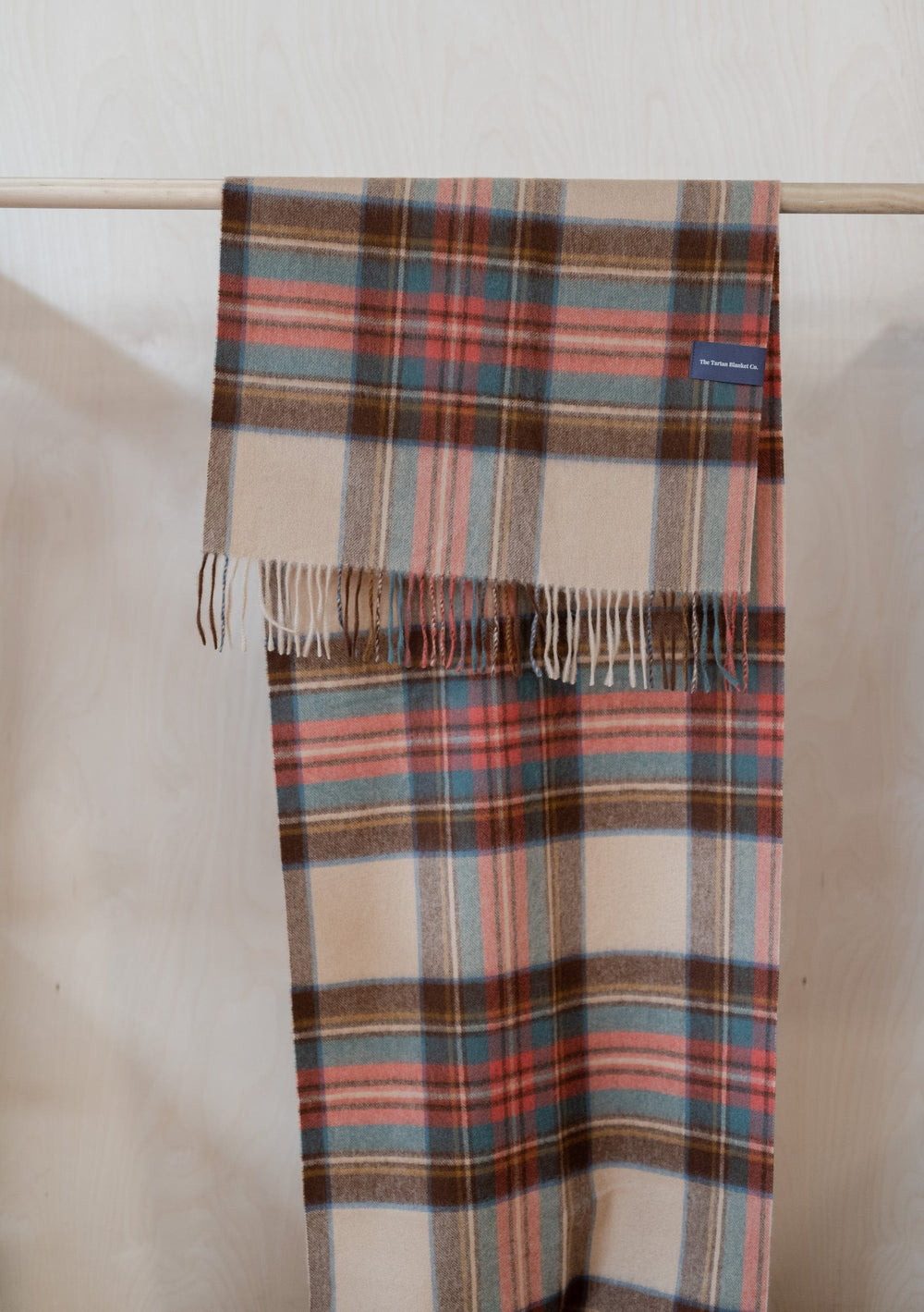 TBCo Lambswool Oversized Scarf in Stewart Dress Antique Tartan draped over wooden rail showing plaid pattern and fringe detail