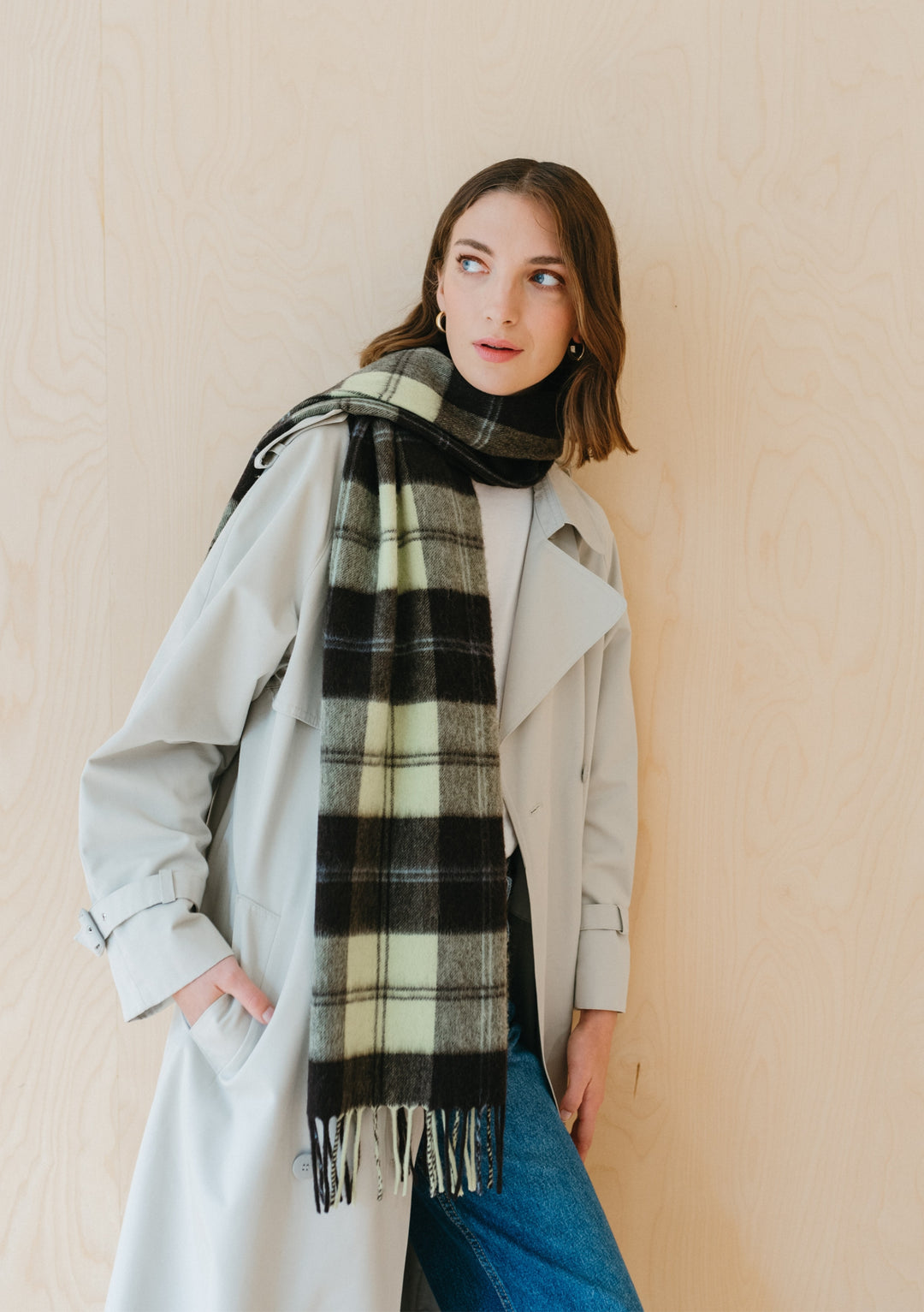 TBCo lambswool oversized scarf in mint varsity check pattern styled with cream trench coat against beige backdrop