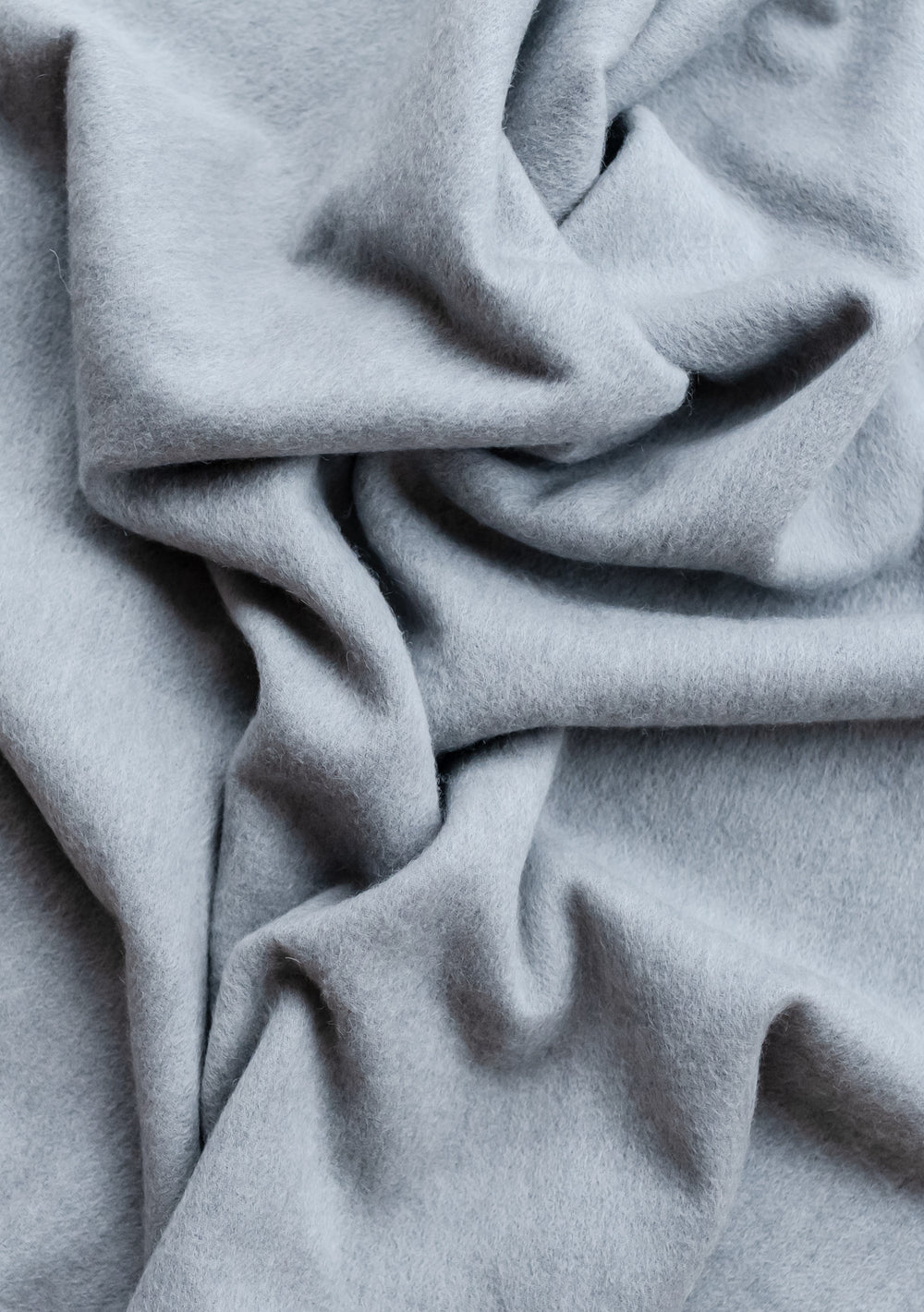 TBCo Cashmere Small Blanket in Light Grey Melange showing soft folds and luxurious texture of pure cashmere fabric