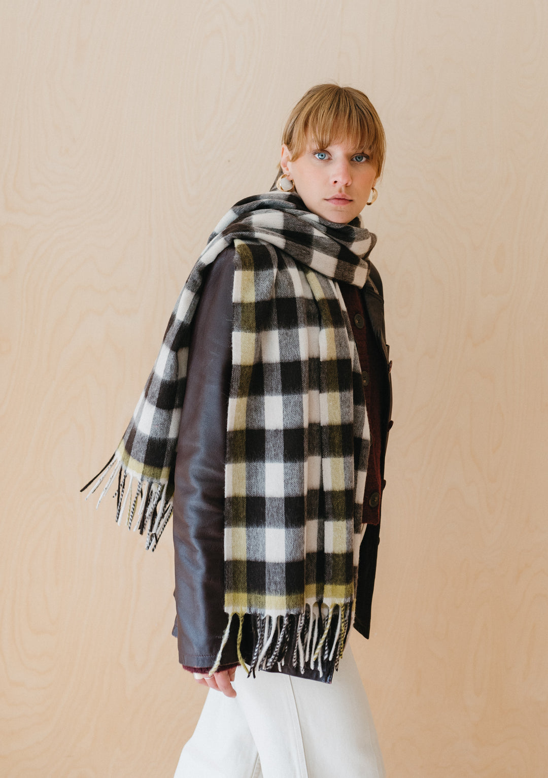 TBCo Lambswool Blanket Scarf in monochrome gingham pattern draped over shoulder, showing fringed edges and checkered design