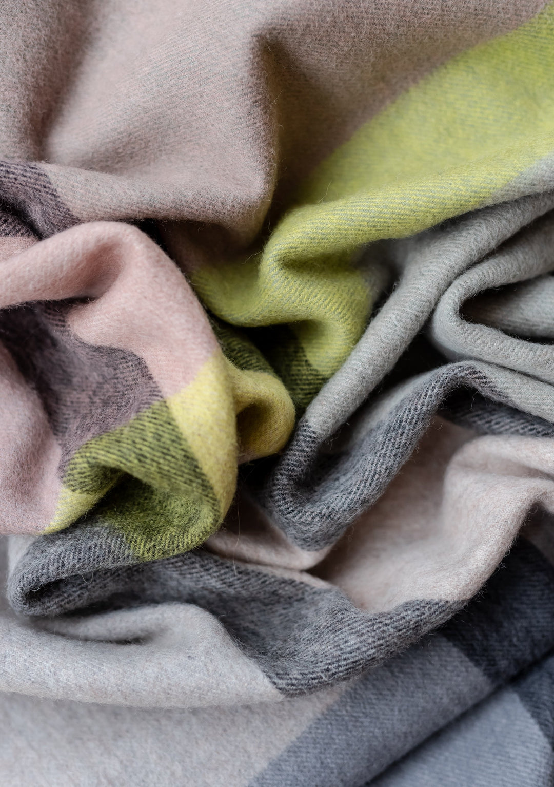 TBCo Lambswool Blanket Scarf in Slate Modern Check featuring soft folds of grey, rose pink and lime green wool fabric