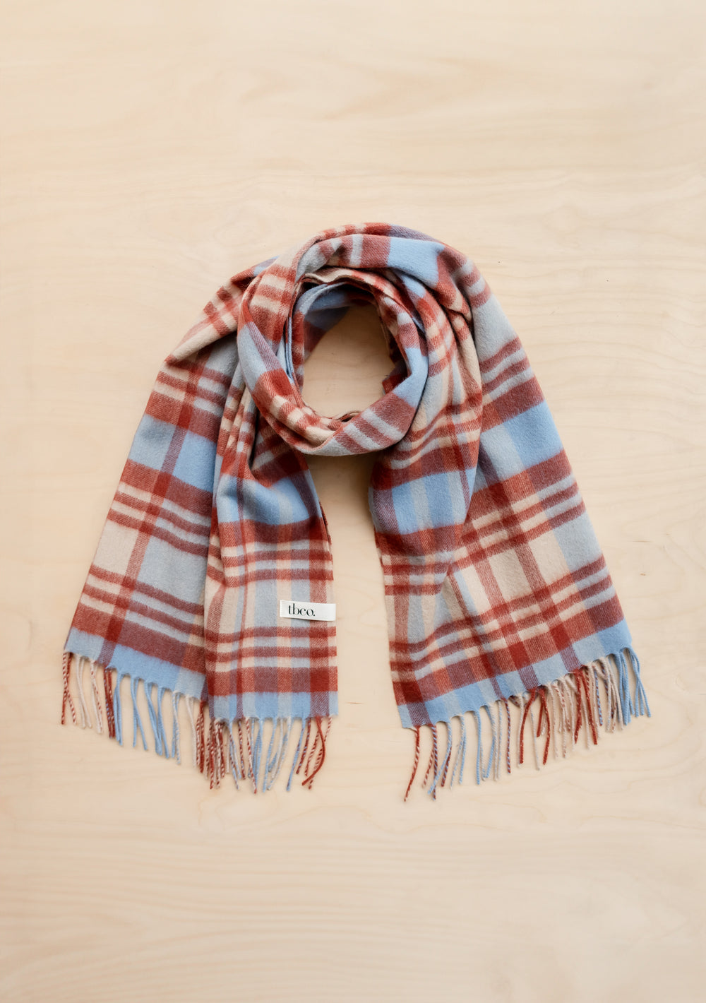 TBCo Lambswool Blanket Scarf in blue and clay red tartan check pattern with fringed ends, displaying luxurious wool texture