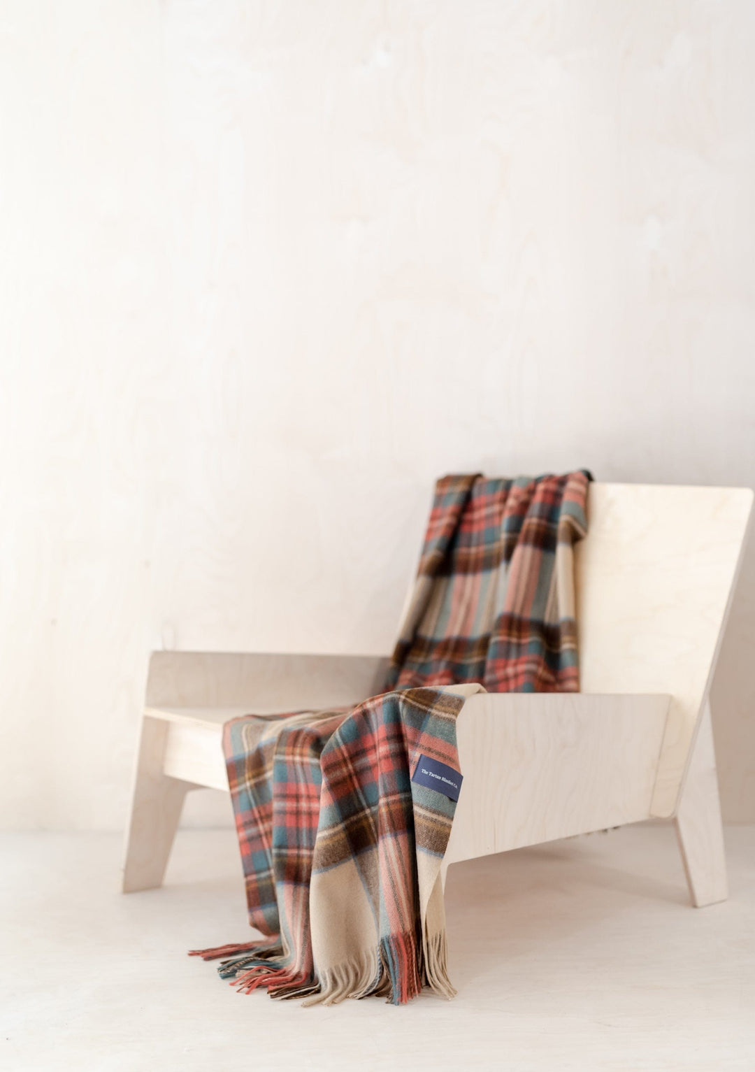 TBCo Lambswool Small Blanket in Stewart Dress Antique Tartan draped elegantly over white chair showing traditional plaid pattern