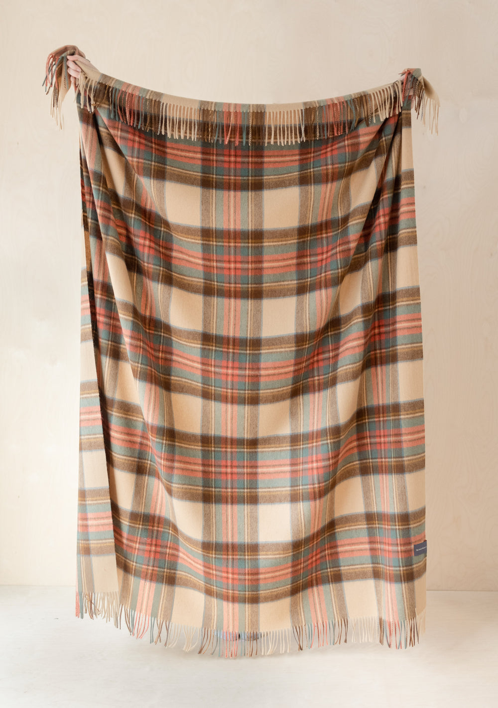 TBCo Stewart Dress Antique Tartan cashmere blanket with fringed edges, displayed hanging in camel, brown, red and green plaid pattern