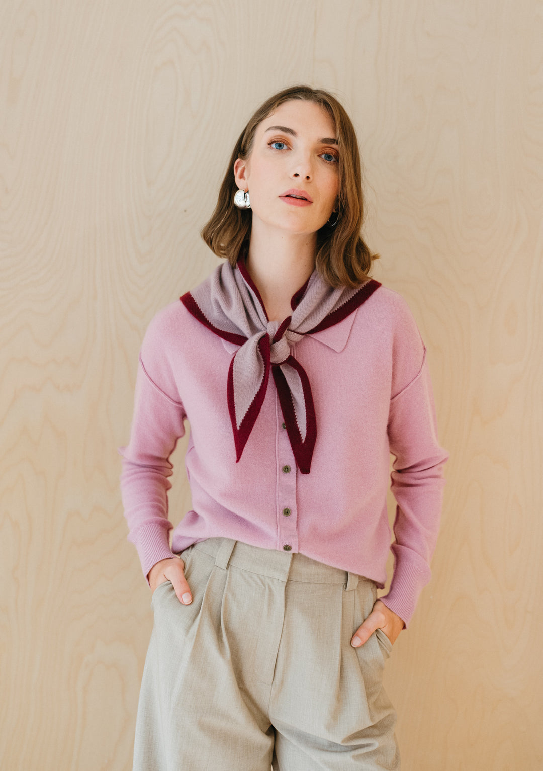 TBCo Merino Triangle Scarf in lilac and burgundy styled with pink cardigan, elegantly draped in bow-tie fashion