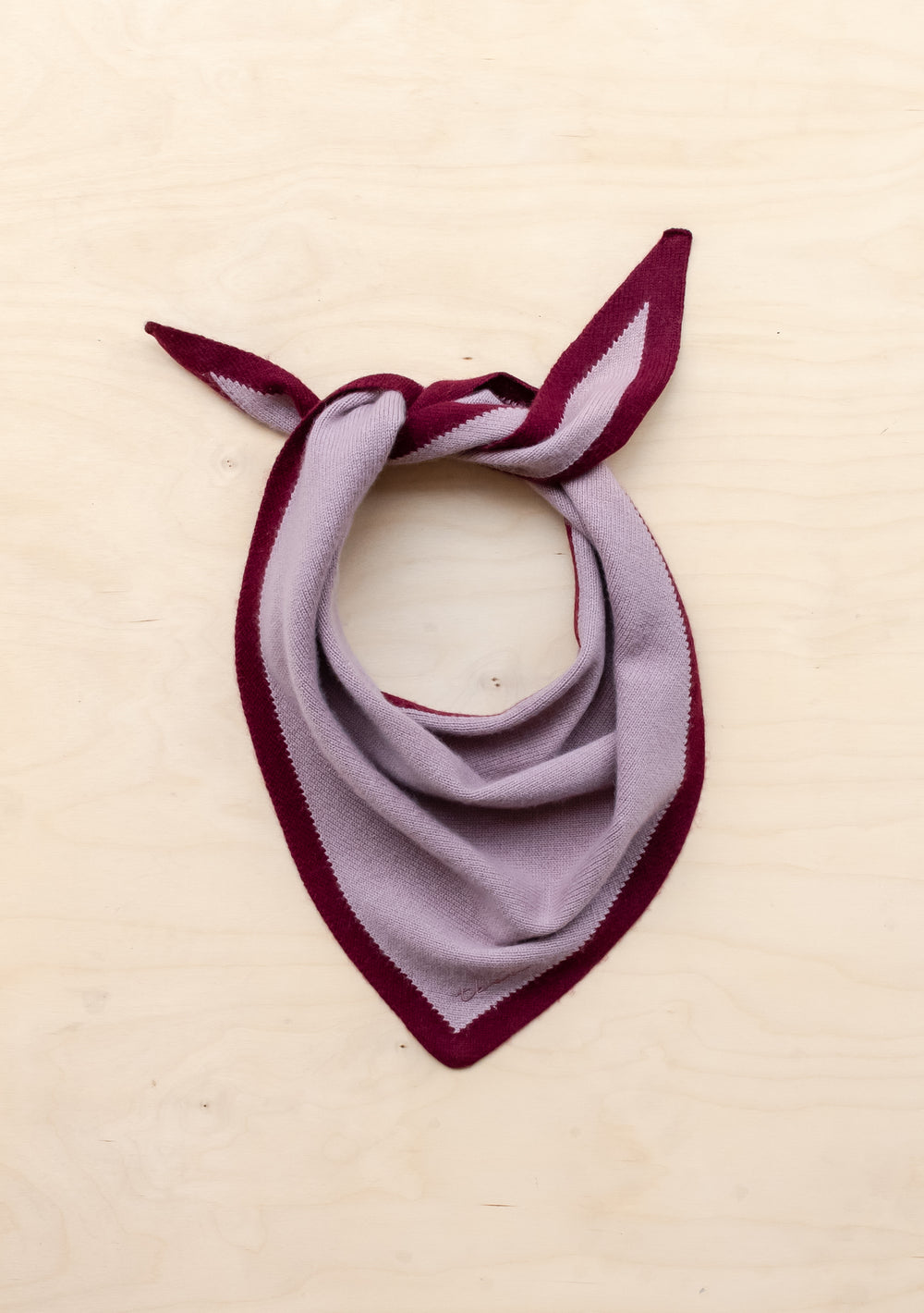 TBCo Merino Triangle Scarf in lilac with burgundy trim, knotted to display dual-tone colours and triangular shape on cream background