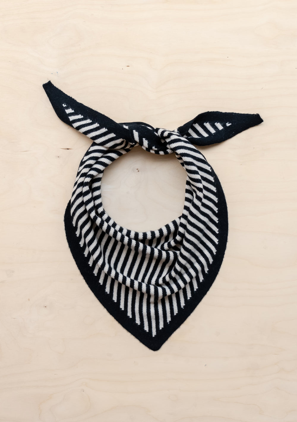 TBCo Merino Triangle Scarf in Black Stripe styled in bandana knot on beige background showcasing classic stripe pattern