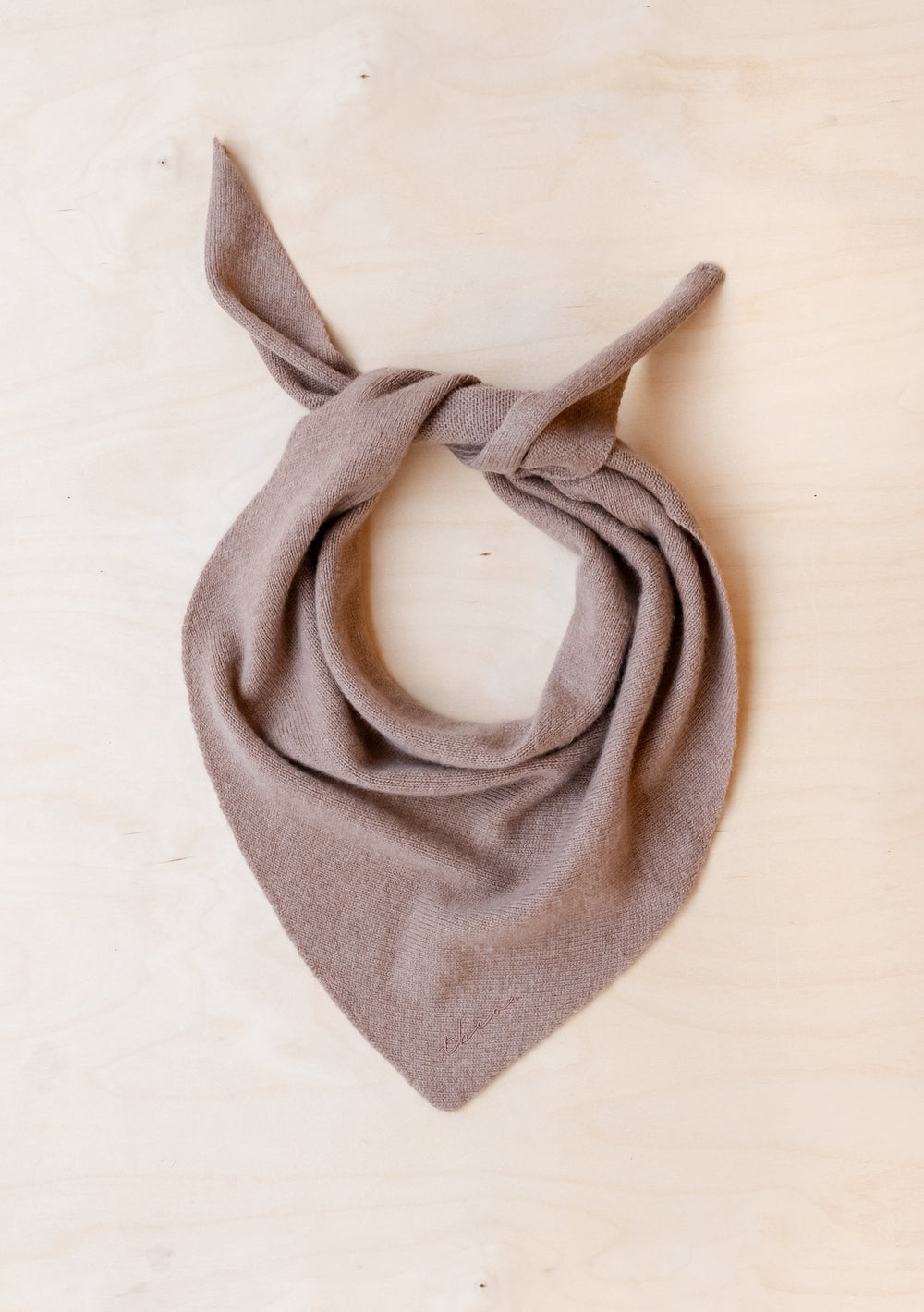 TBCo Merino Triangle Scarf in Coffee, styled in a bandana tie on cream background, showcasing soft brown merino wool texture