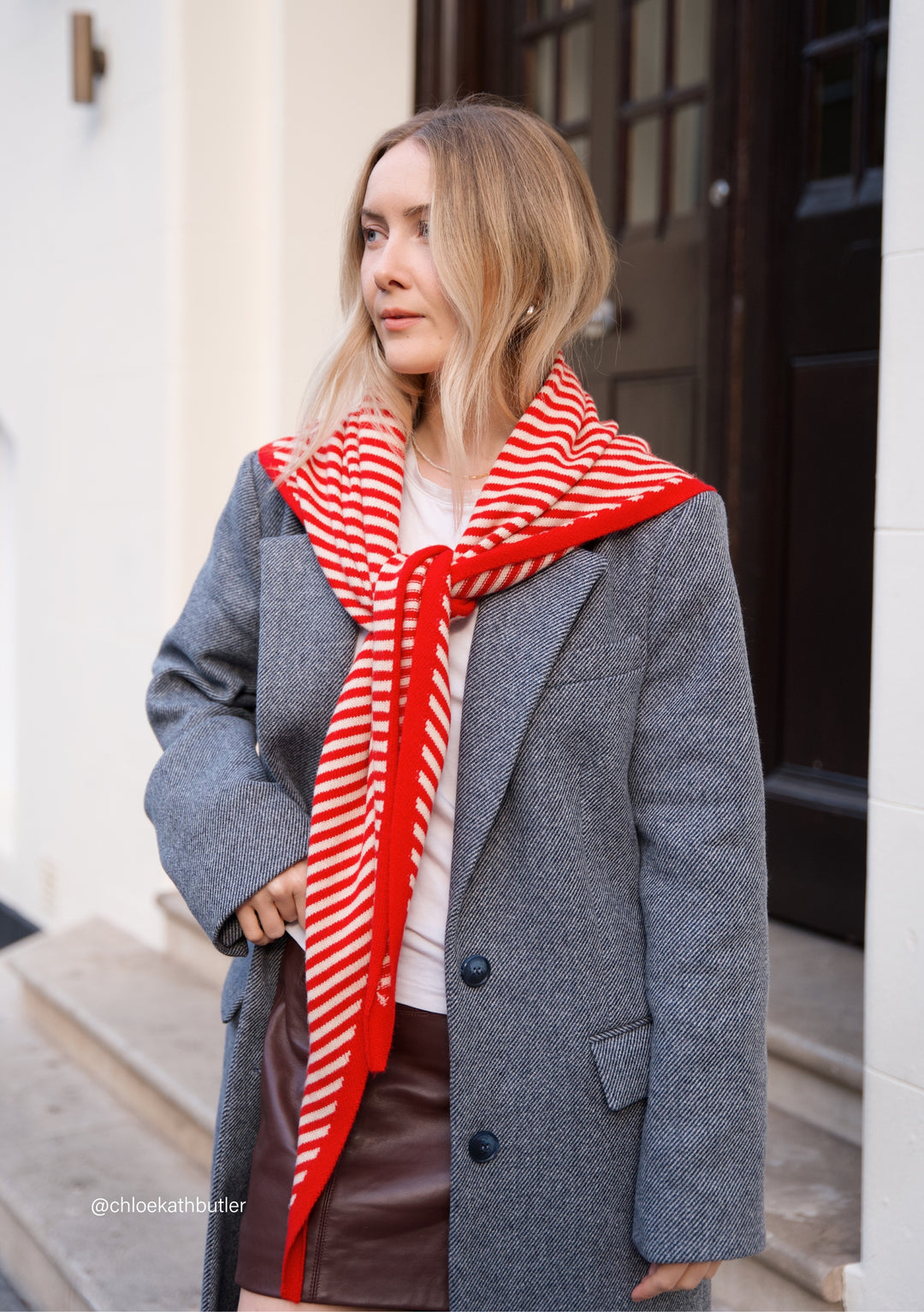 TBCo Merino Triangle Scarf in red and cream stripes styled over grey coat, showcasing versatile winter styling options