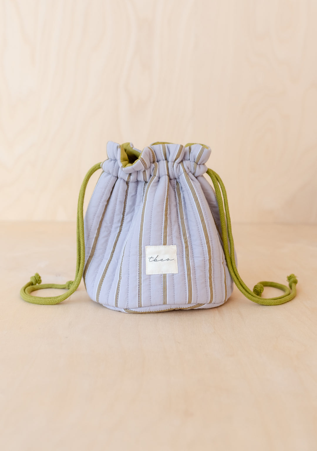 TBCo Cotton Wash Bag in Lilac Stripe with green drawstring, featuring vertical stripes and signature label