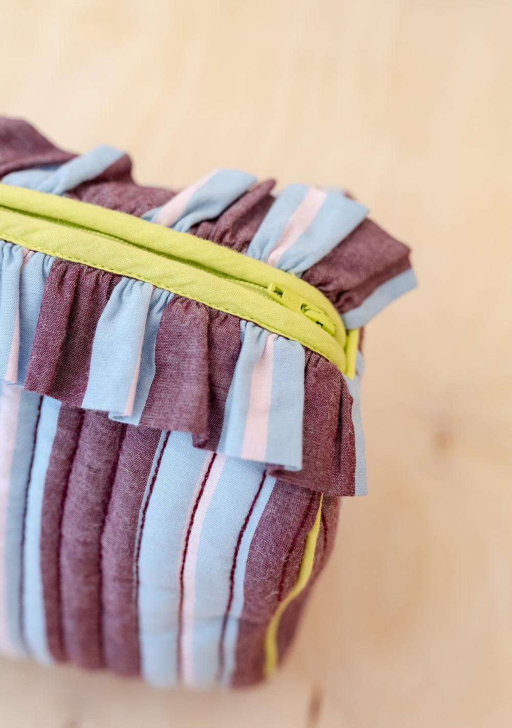 TBCo x Glassette Cotton Wash Bag in Berry Stripe, featuring quilted fabric, ruffled trim, chartreuse zipper, and multiple compartments, perfect for storing toiletries.