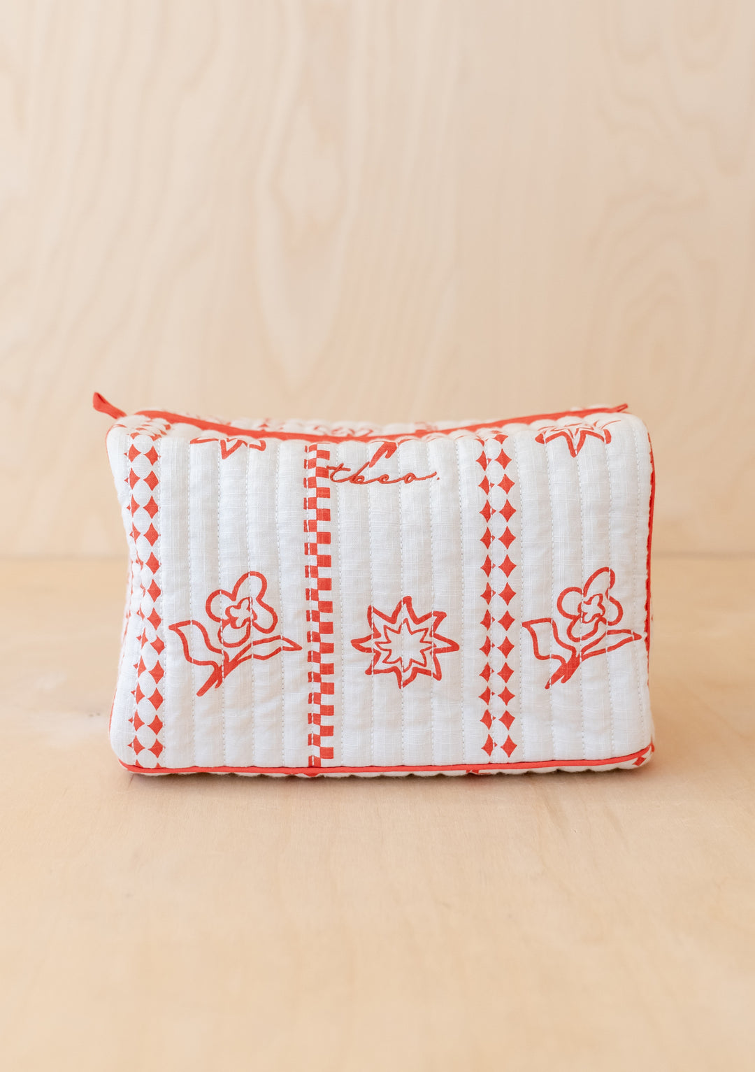 TBCo Cotton Wash Bag in Flora featuring white quilted fabric with coral floral pattern and sunshine motifs, zip closure