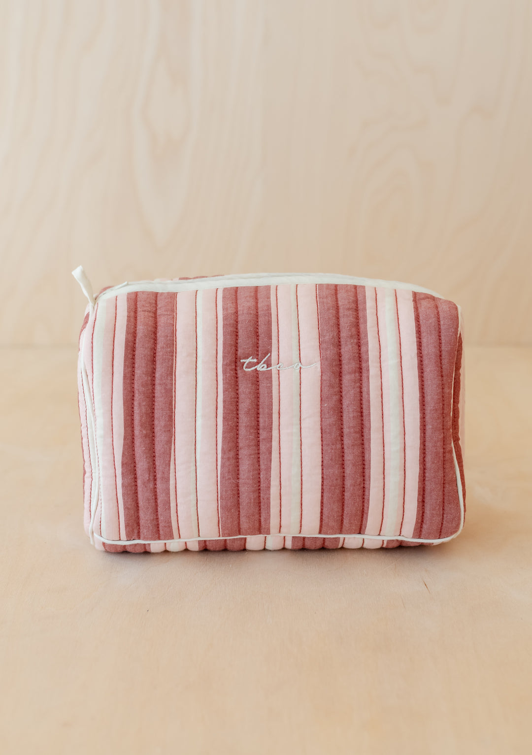 TBCo Cotton Wash Bag in Red Stripe featuring quilted vertical stripes in pink and cream with embroidered logo and zip closure